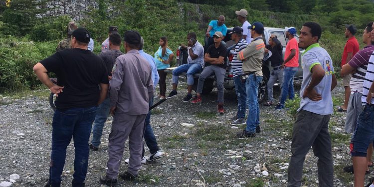 Gente mirando hombre muerto